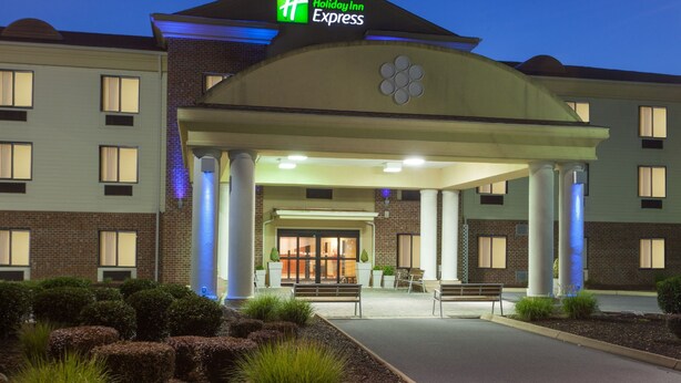 A Holiday Inn Express hotel with a covered entrance, outdoor seating, and a landscaped area. - Holiday Inn Express Charles Town by IHG (Charles Town)