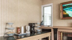 Une cuisine avec un papier peint à rayures, un coin café, une cheminée et une fenêtre donnant sur un beau paysage.