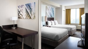 A hotel room with a desk, two beds, a TV, and artwork on the walls. - SpringHill Suites by Marriott Bakersfield (Bakersfield)