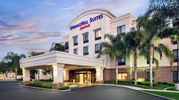 A Springhill Suites Marriott hotel with a covered entrance, palm trees, and a clear sky. - SpringHill Suites by Marriott Bakersfield (Bakersfield)