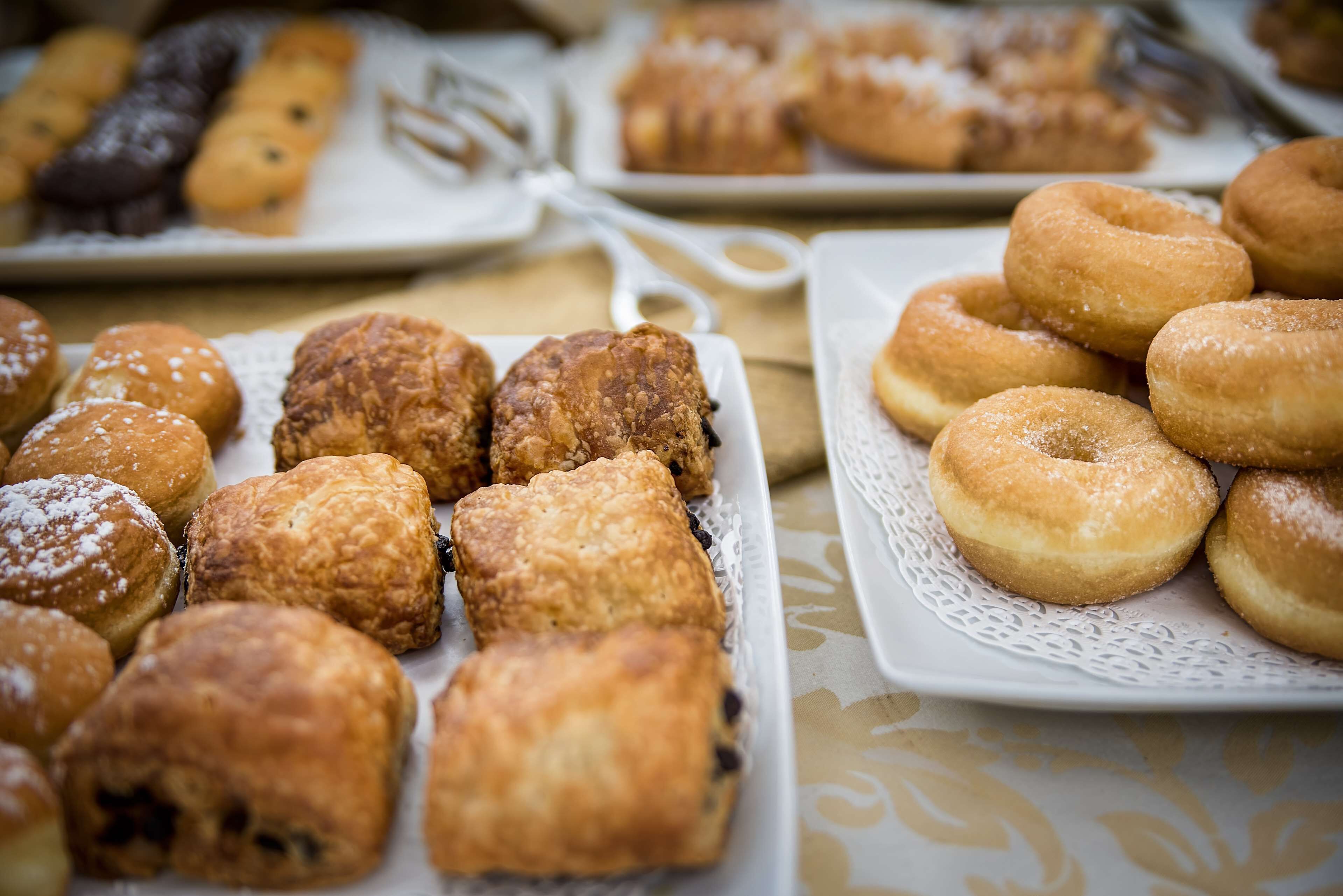 Variedad de pasteles sobre platos blancos con encajes.