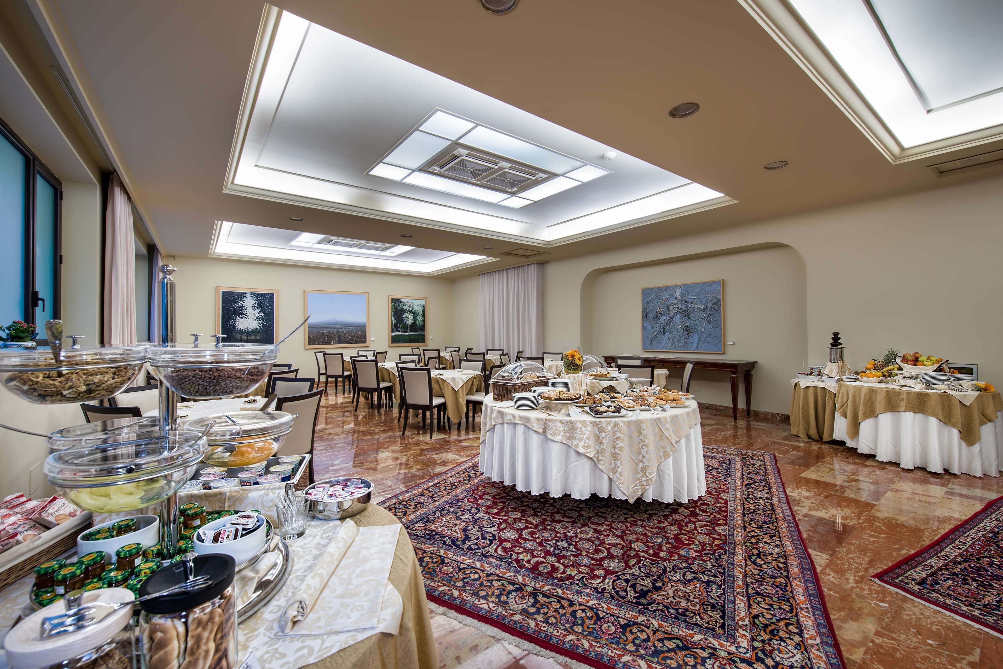 Un amplio salón de banquetes con techos altos, tragaluces y una mesa redonda central con mantel blanco.