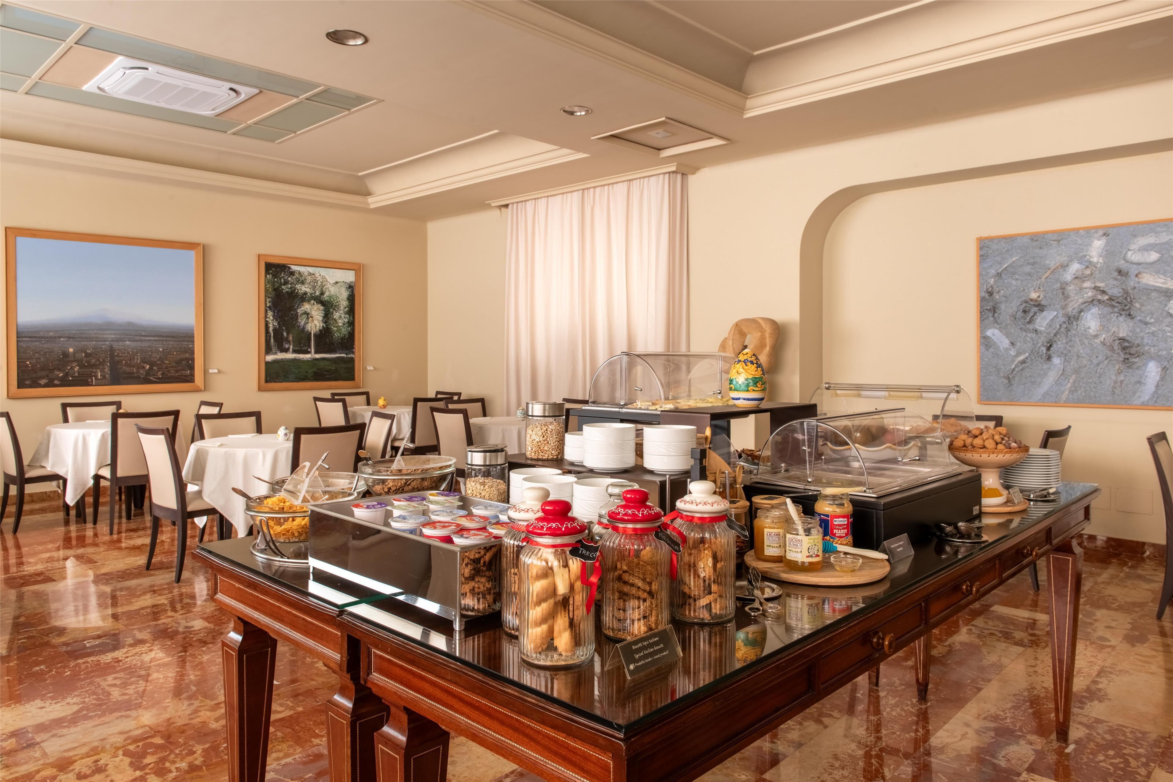 Ein Buffetbereich mit verschiedenen Speisen, einer Kaffeestation und Sitzmöglichkeiten.
