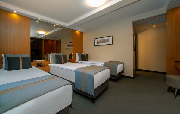 A hotel room with three beds, a desk, and a chair. - Tan Hotel - Special Class (Istanbul)