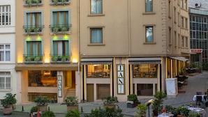 A hotel with multiple floors, outdoor seating, and a sign for 'TAN BRASSERIE'.