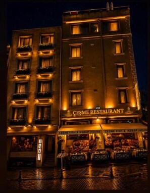 A building with a sign for 'CESME RESTAURANT' and 'CESME FISH & KEBAP HOUSE' at the ground level. - Tan Hotel - Special Class (Istanbul)