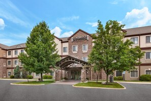 Staybridge Suites -hotelli, jossa on tiiliverhous, suuret ikkunat ja katettu sisäänkäynti.