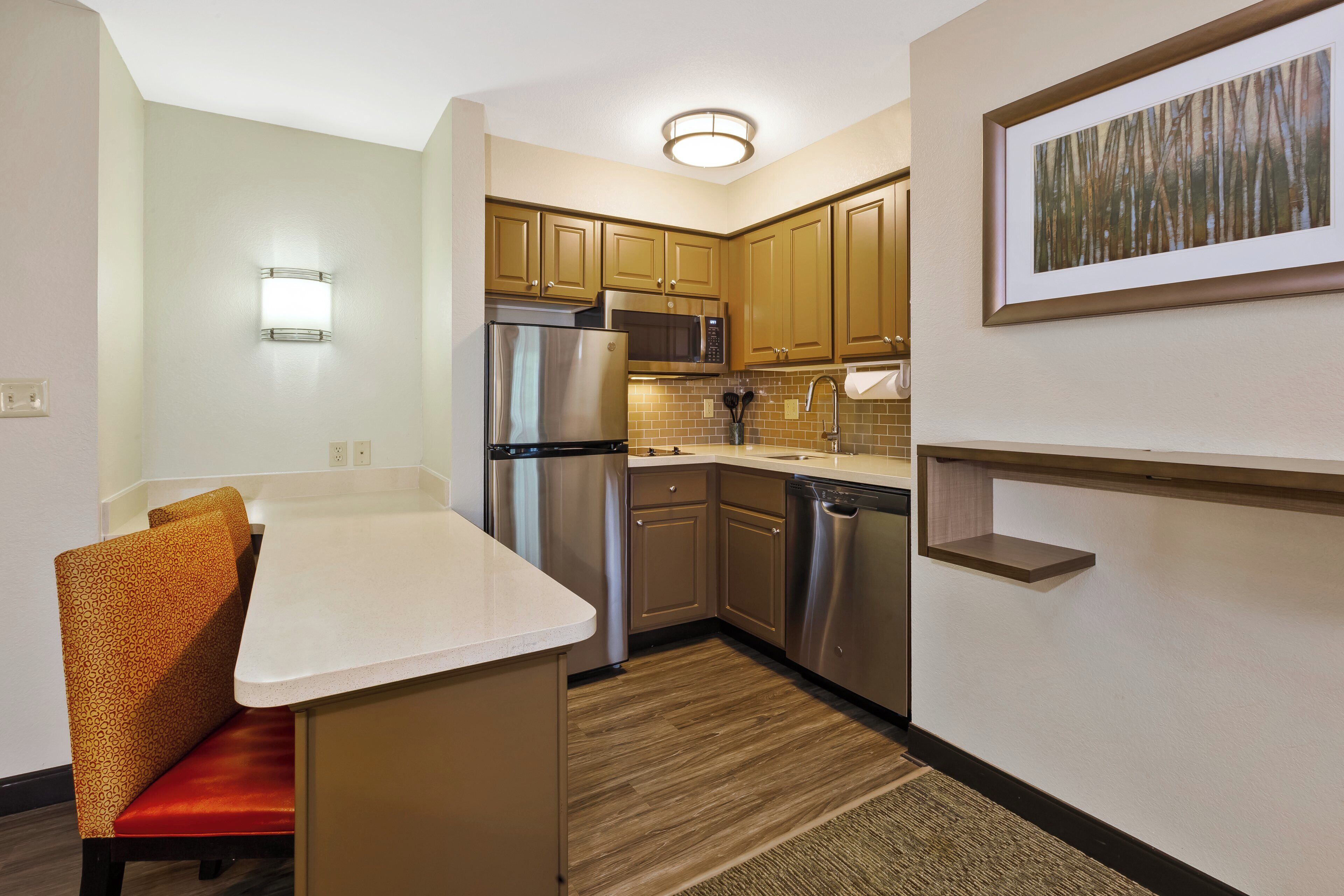 A compact kitchen with stainless steel appliances, a microwave, and a sink.