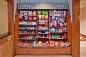 Un présentoir proposant des bonbons, des articles divers et des en-cas dans un magasin.