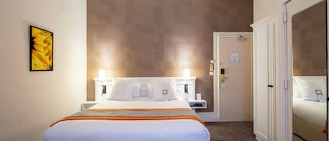 Ein Hotelzimmer mit einem großen Bett, einem Nachttisch, einem Kleiderschrank und einer Wand-Klimaanlage.