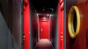 A hallway with red doors and a patterned carpet.