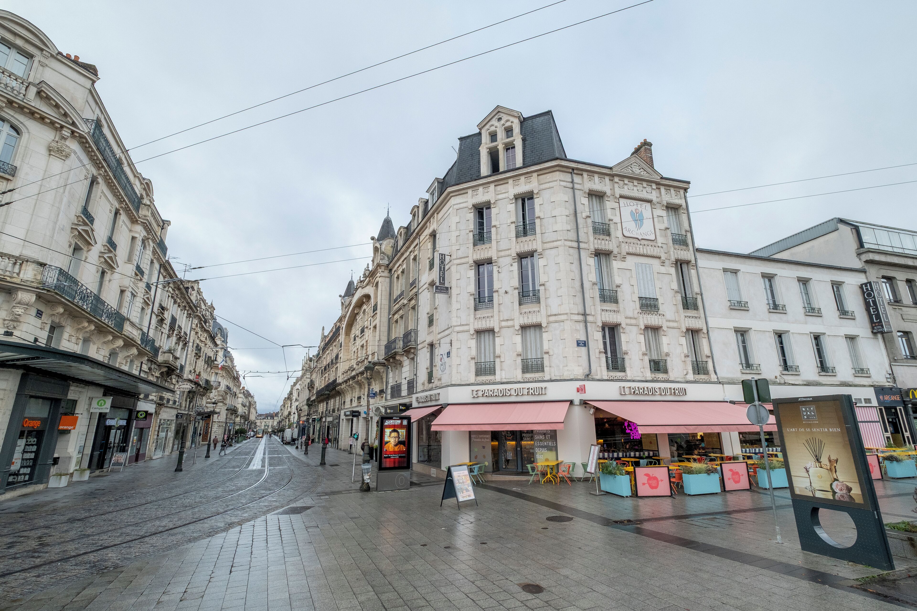 A street view with a building featuring a 'Paradis' sign, indicating a hotel or restaurant.