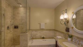 Un baño con ducha, bañera y lavamanos, que incluye un espejo, toallero y artículos de aseo.