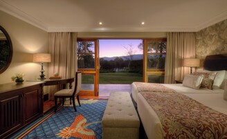 Una habitación de hotel con cama, escritorio, silla y vistas al exterior.