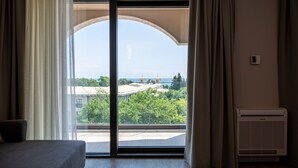 Deluxe suite, uitzicht op zee | Een bureau, verduisterende gordijnen, beddengoed