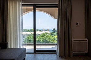 Suite Deluxe, vista al mar | Escritorio, cortinas blackout y ropa de cama 