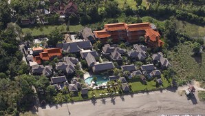 An aerial view of a resort with multiple buildings, a swimming pool, and a beach. - Grand Balisani Suites Hotel (Keroboken Kelod)