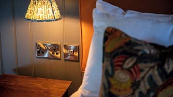 A room with a wooden table, a wall-mounted light fixture, and a power outlet.