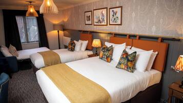 A hotel room with two beds, a desk, and a chair.