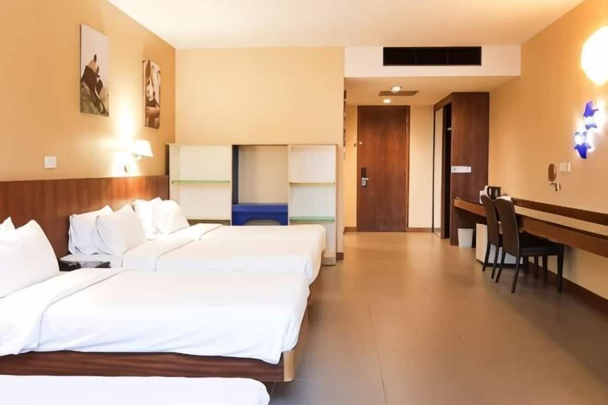 Una habitación de hotel con dos camas, un escritorio y una silla.