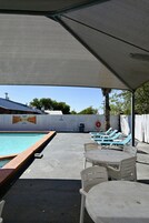 Una piscina al aire libre, sillones reclinables de piscina