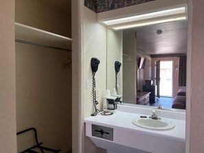 Bathroom features a sink, mirror, and hair dryers, as well as a coffee maker.