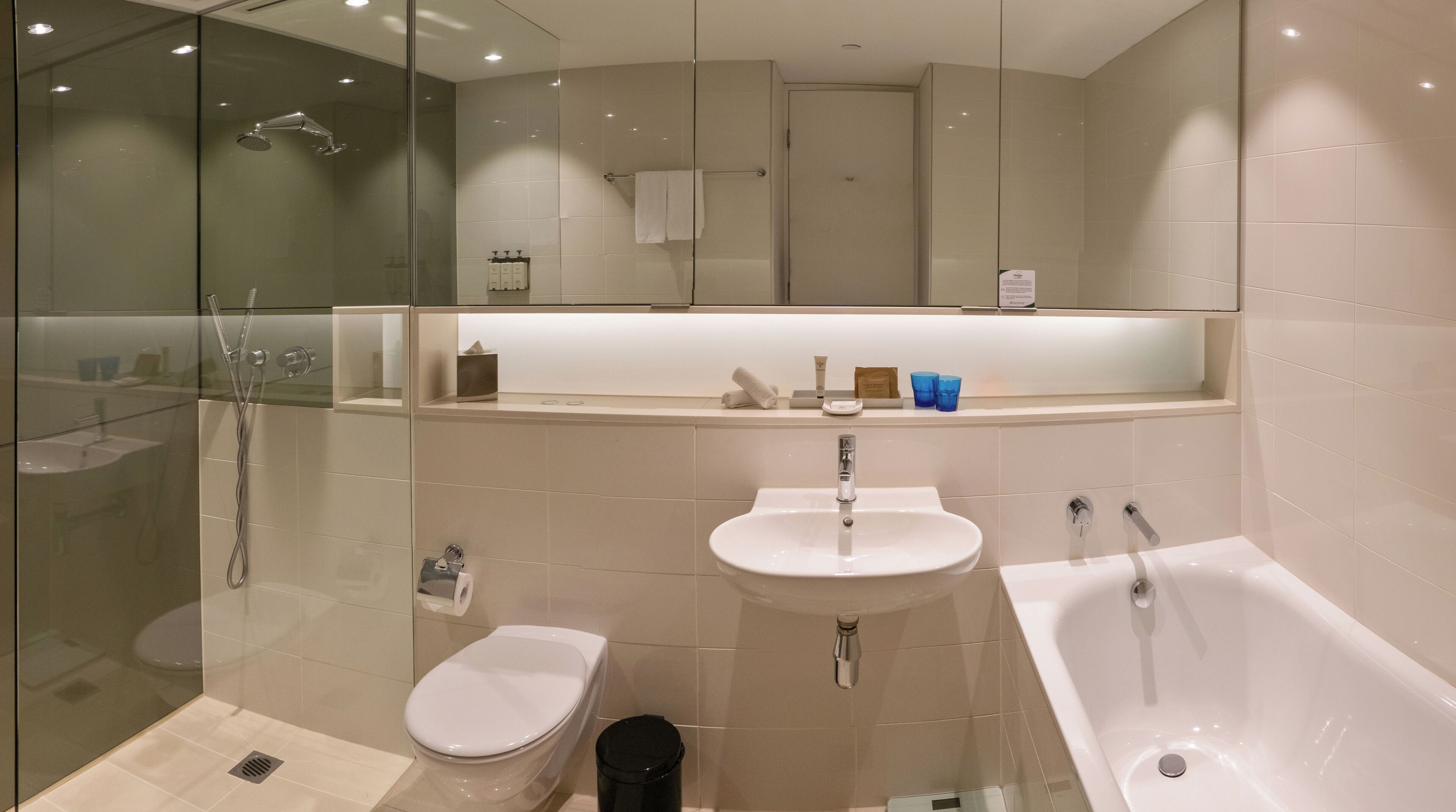 A modern bathroom with a glass-enclosed shower, a toilet, a sink, and a bathtub.