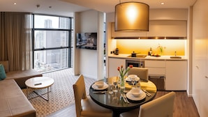 A modern hotel room with a living area, dining space, and kitchenette. - Fraser Suites Sydney (Sydney)