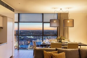 A modern dining area with a city view, large windows, and contemporary furnishings. - Fraser Suites Sydney (Sydney)