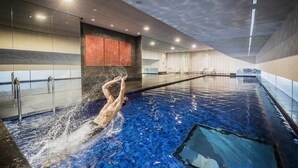 A swimming pool with a person diving into the water. - Fraser Suites Sydney (Sydney)