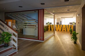 Un interior moderno con una escalera, un separador de vidrio y una zona de recepción.