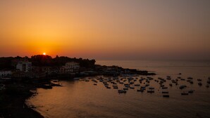 Un pueblo costero al atardecer con barcos anclados en el agua.