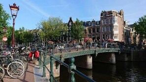 A canal with a bridge, bicycles, and historic buildings. - Hotel Mozart (Amsterdam)