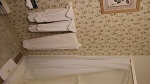 A bathroom with a bathtub, a shower, and a toilet. There are towels hanging on the wall. - Sea Breeze Inn (Hyannis)