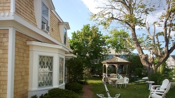 A house with a brick exterior and a covered patio area. - Sea Breeze Inn (Hyannis)