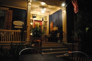 A porch with a 'Welcome' sign, outdoor seating, and a staircase leading to the entrance.