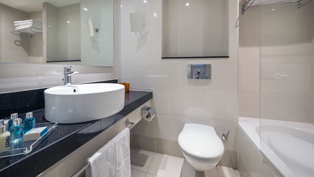 A modern bathroom with a large sink, toilet, and bathtub. - Yam Suf by Isrotel Collection (Eilat)