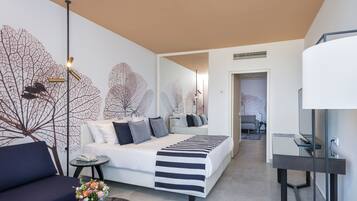 Un dormitorio moderno con cama, sofá, mesita de noche y lámpara.