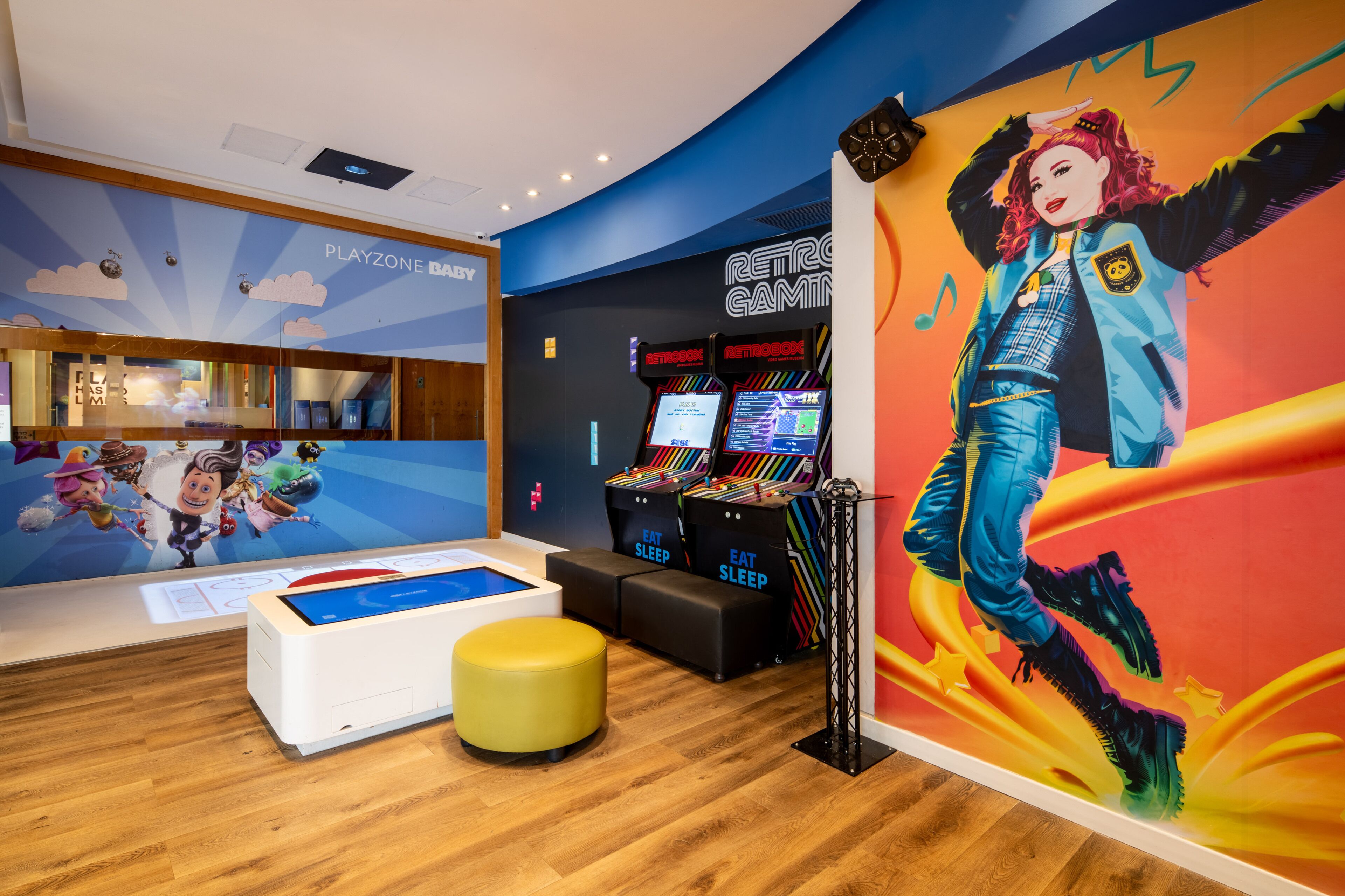 A Playzone Baby area with arcade games, a Playzone Baby pool table, and a colorful mural.