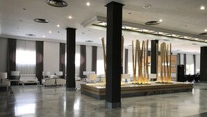 A spacious lobby with a central water feature, multiple seating areas, and a modern ceiling design.