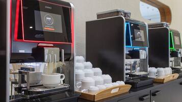 Una estación de café con varias máquinas de espresso, cada una con pantalla digital y portacopas.
