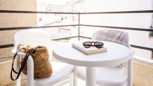 A balcony with a white table and chairs, a woven bag, and a pair of sunglasses on the table. - RVHotels Mar de Tossa (Tossa de Mar)