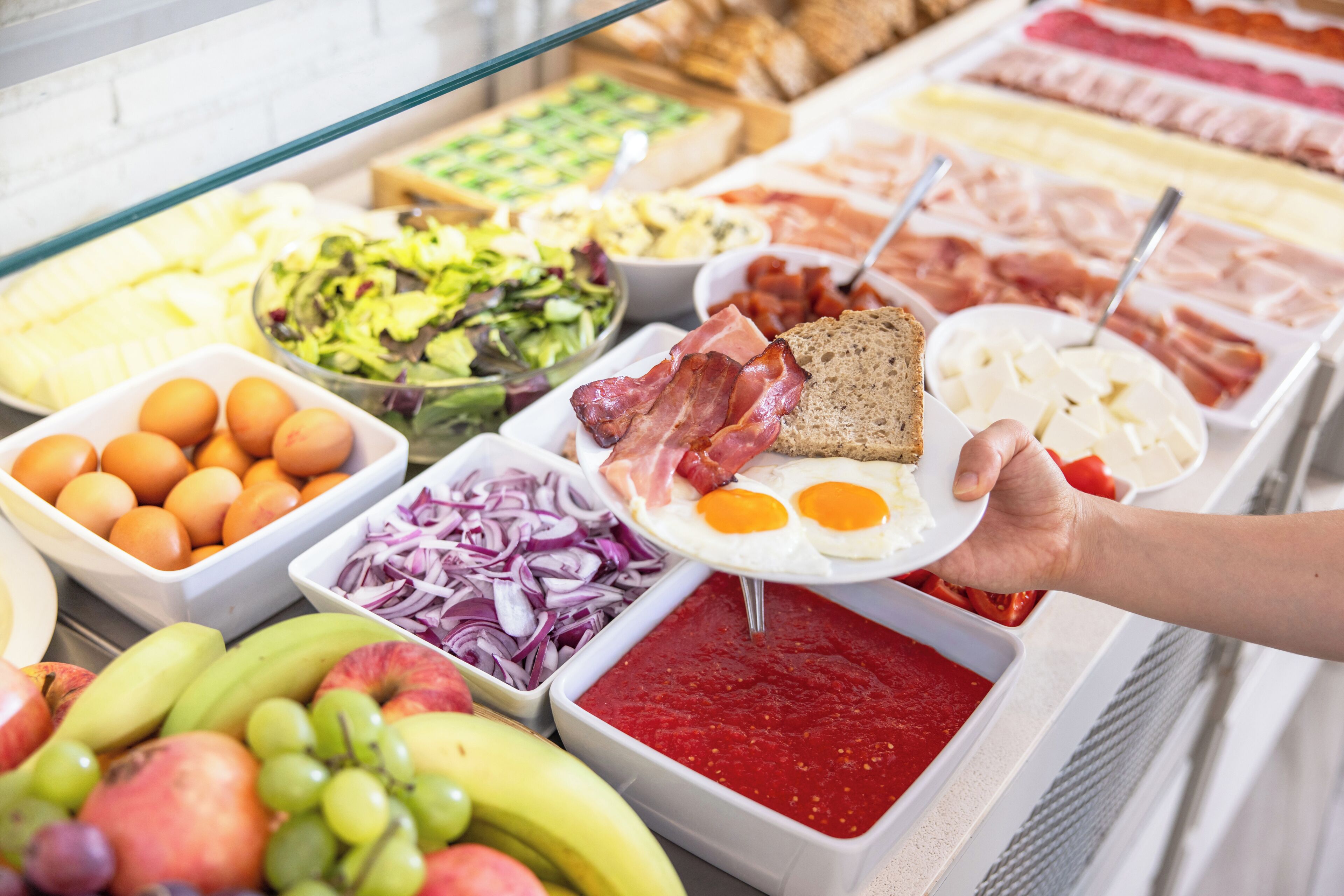 En buffet med et udvalg af mad, herunder frugt, grøntsager, kød og æg.