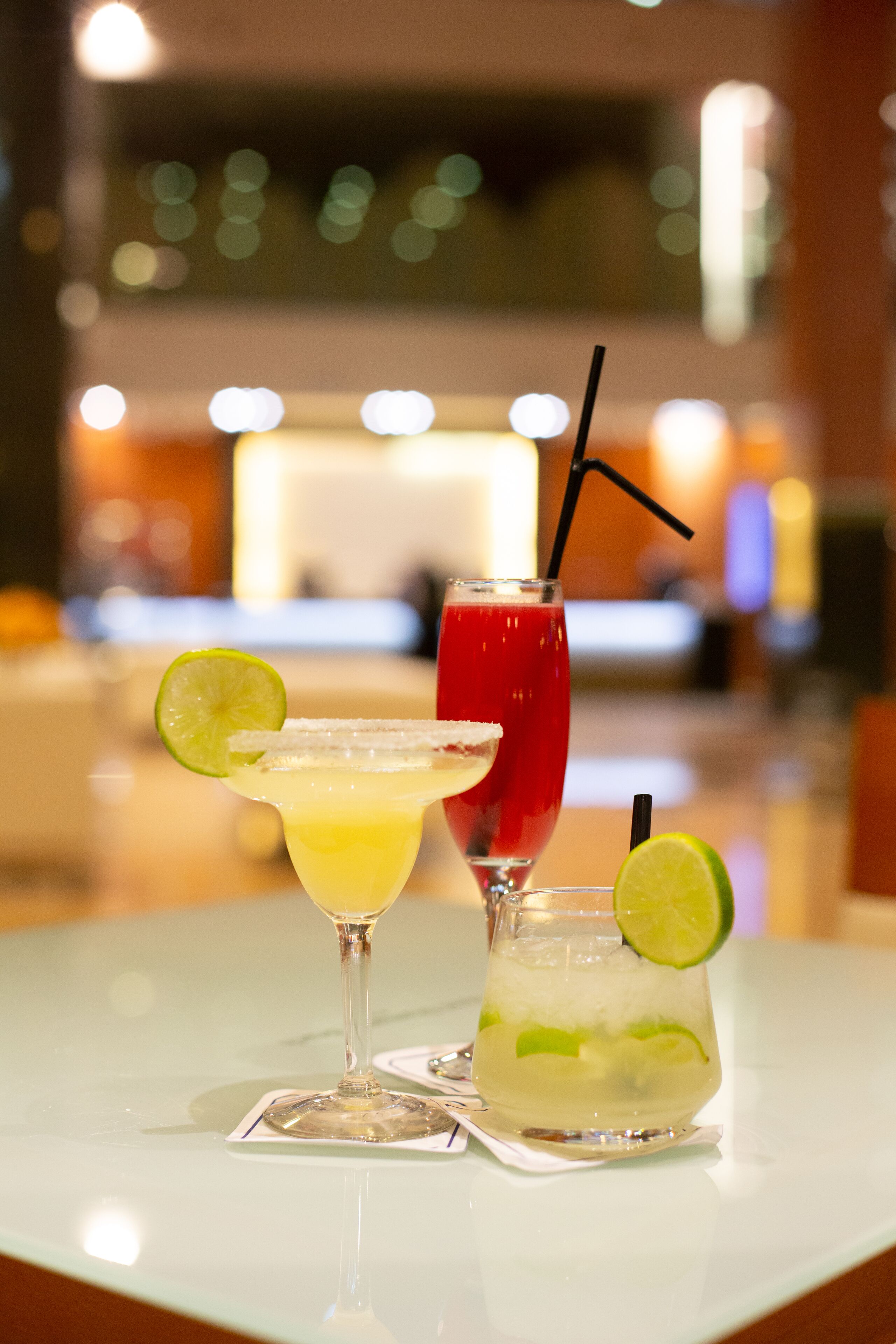 Three drinks on a table with a blurred background.