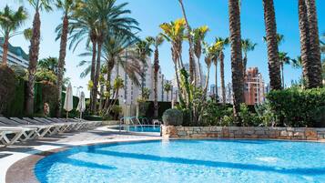 Una piscina al aire libre, tumbonas