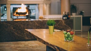 Een bar met een marmeren aanrecht, een kleine plant in een pot en een glas vruchtensap.