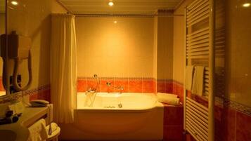 Un baño con bañera, inodoro y lavabo.