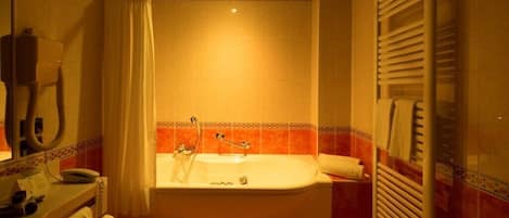 Un baño con bañera, inodoro y lavabo.