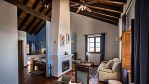 Amplia sala de estar con chimenea, un sofá y un comedor.