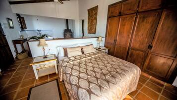 Un dormitorio con una cama grande, un armario de madera y un ventilador de techo.